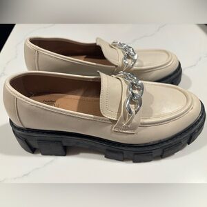 Cream and black platform loafers with silver chain